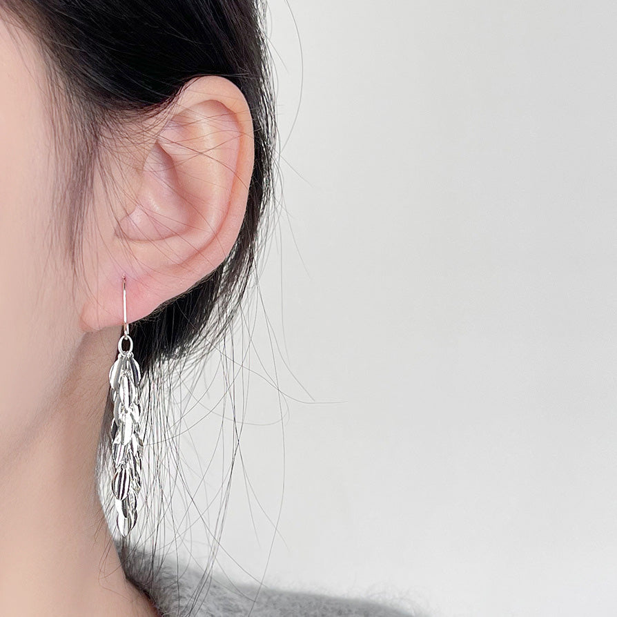 Model showcasing the elegant drape of the silver leaf hook drop earrings.
