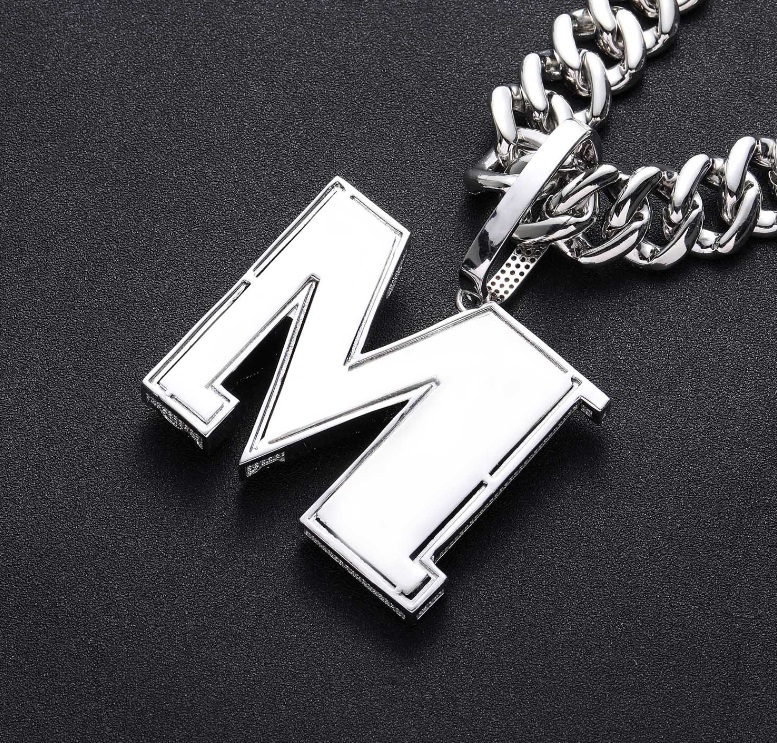 Detailed close-up of a custom silver 'M' pendant for hip hop necklaces
