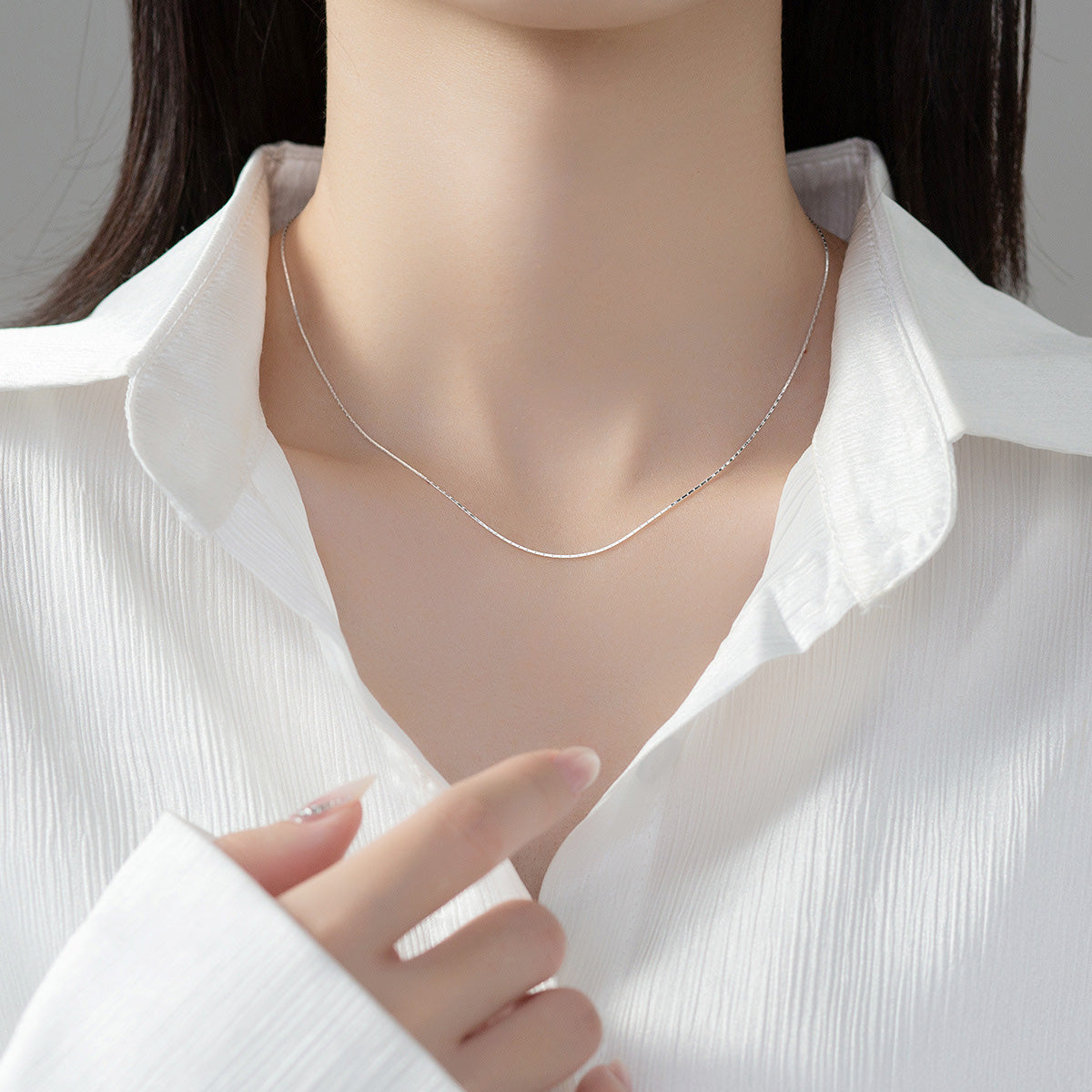 Model showcasing the 925 sterling silver thin snake chain necklace.