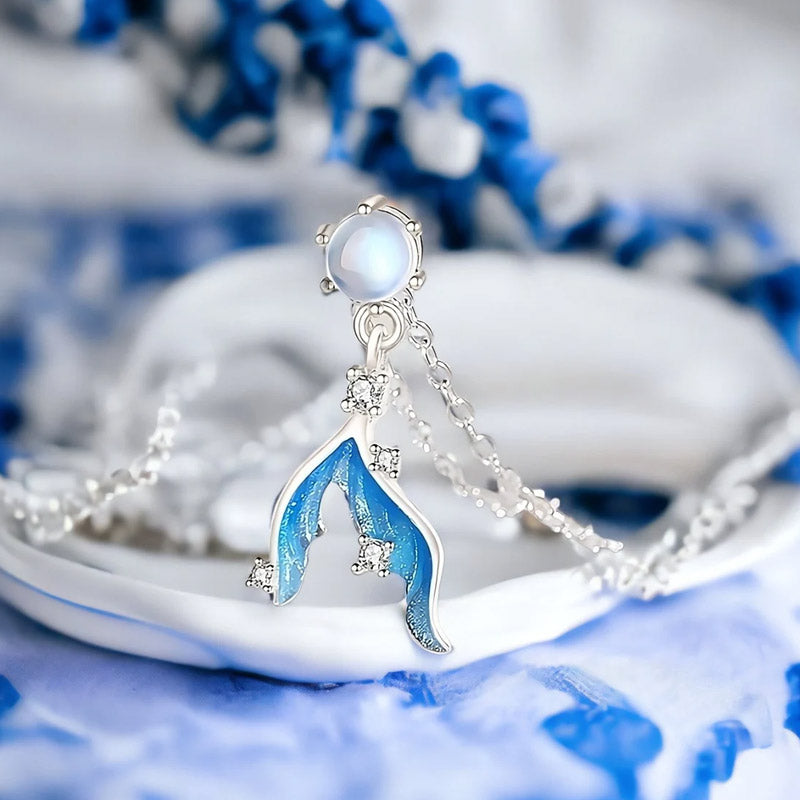 Detailed view of the mermaid tail pendant with its distinctive blue and white enamel and opal-like stone