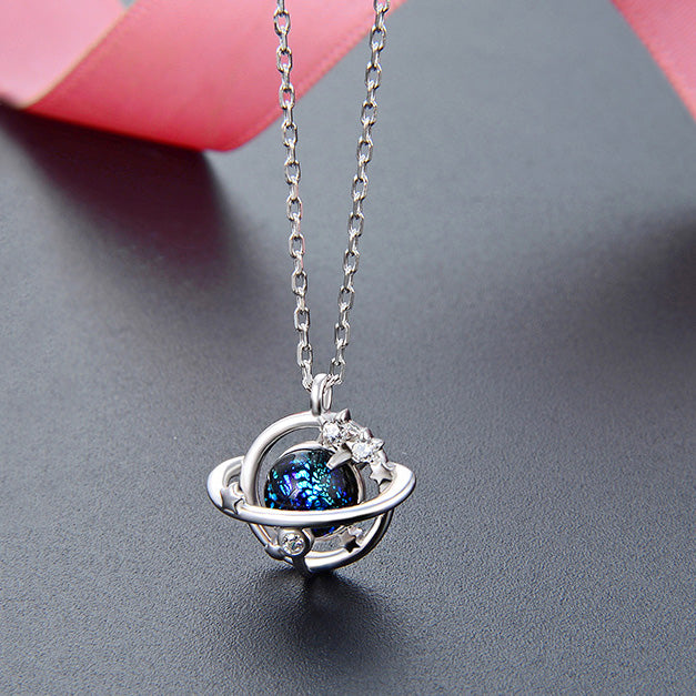 Detailed view of the planet-themed pendant with rings and stars