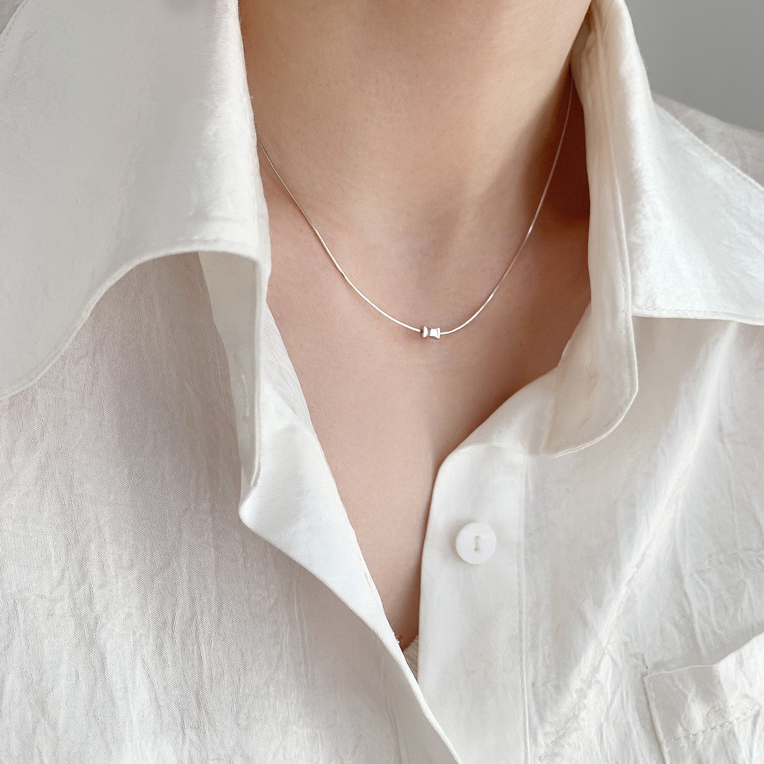 A model wearing the sterling silver cylindrical pendant necklace
