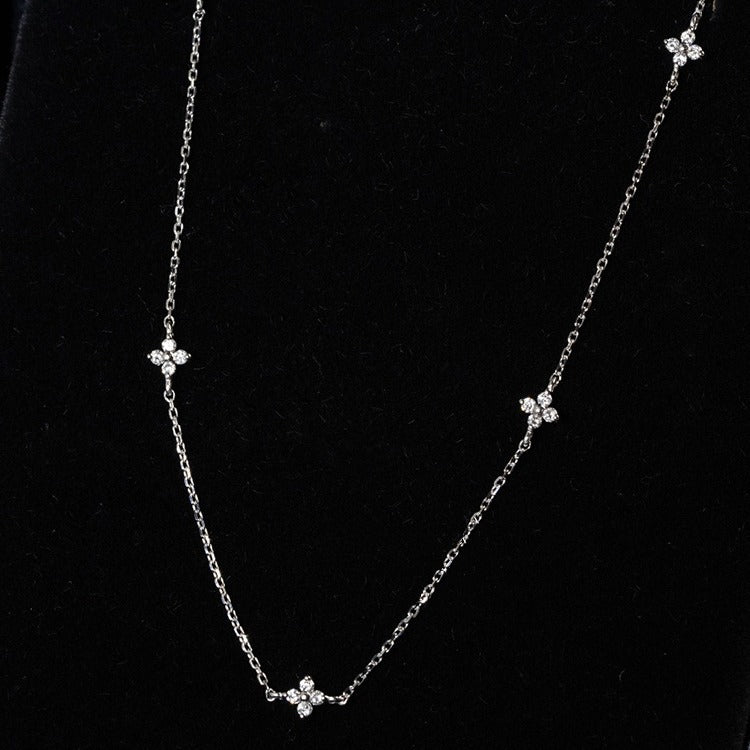 A detailed close-up of the intricate flower cluster design on one of the sterling silver necklaces.