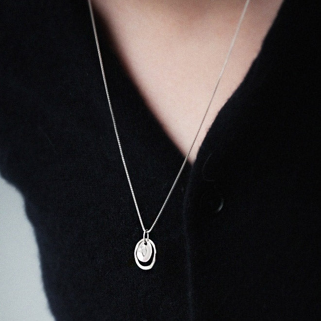 Model showcasing the sterling silver hammered disc charm necklace