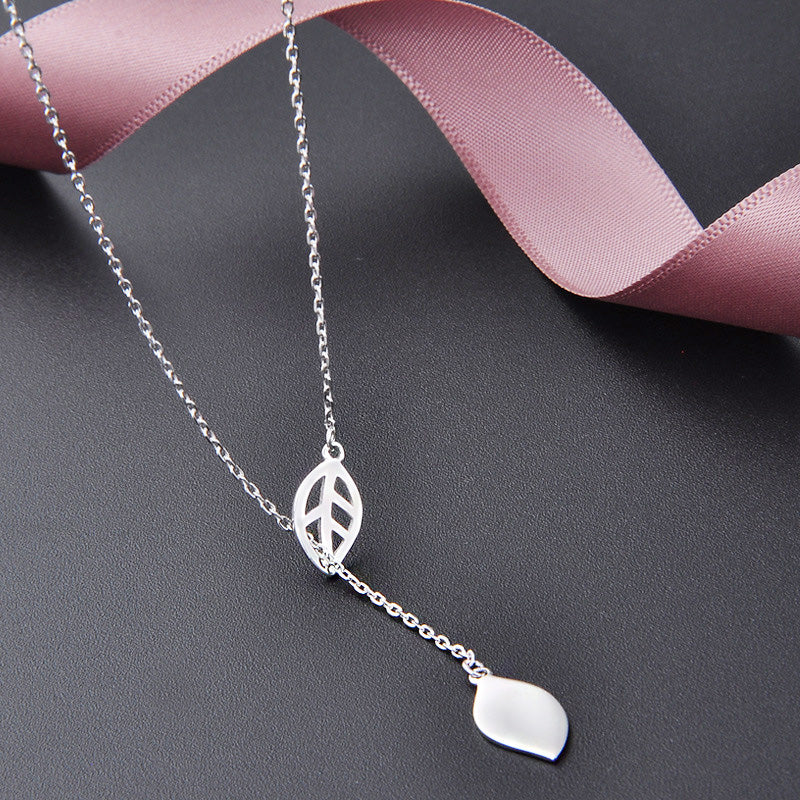 Close-up of the leaf tassel pendants on the sterling silver necklace.