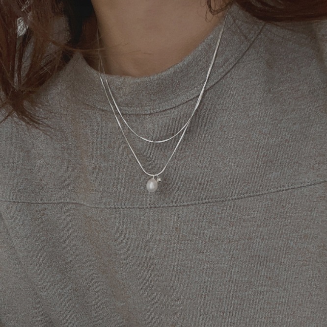 Model wearing the 925 Sterling Silver Layered Chain Pearl Necklace, showcasing its elegant drape.