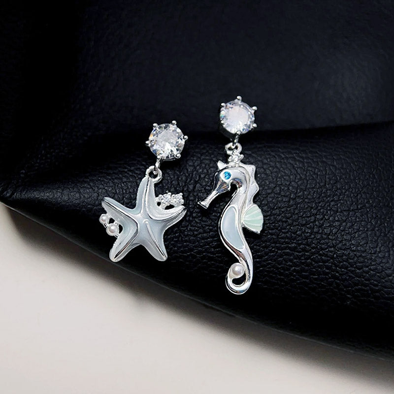 Detailed shot of the starfish and seahorse earrings with pearl and gemstone accents