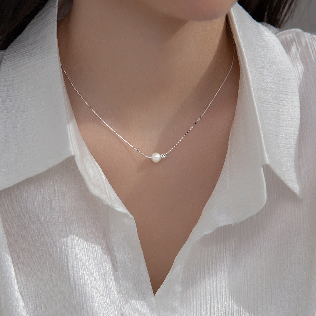 Model showcasing the elegant 925 sterling silver pearl snake chain necklace.