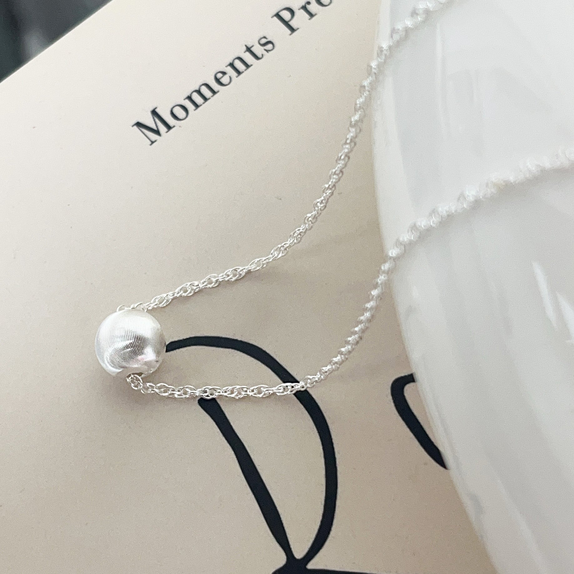 A model showcasing the 925 sterling silver ball charm choker necklace