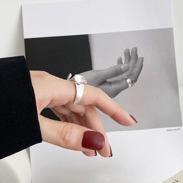 A woman's hand with red nails wearing the sterling silver lotus leaf ring.