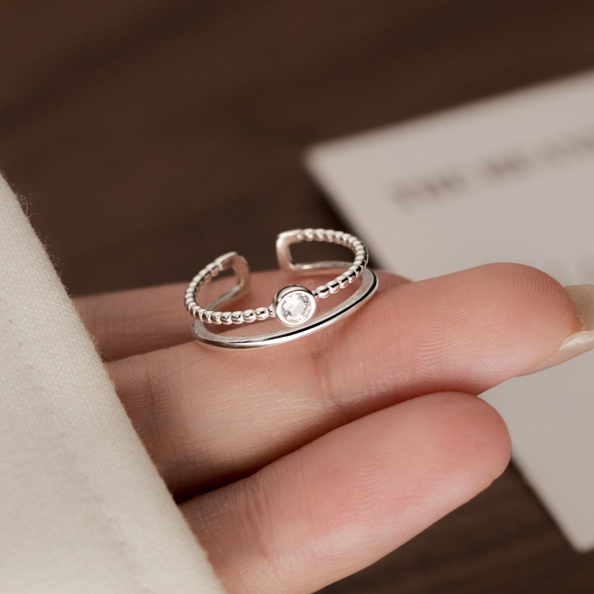 A detailed view of a sterling silver ring with a clear zircon stone from the set.