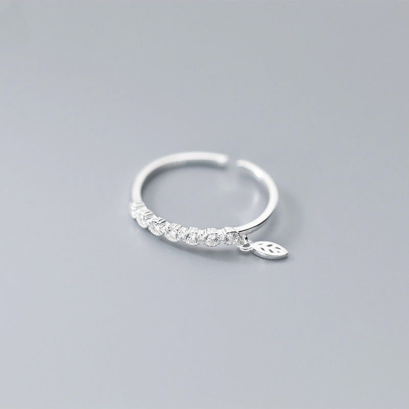 Detailed view of the sterling silver ring's leaf charm and cubic zirconia stone.