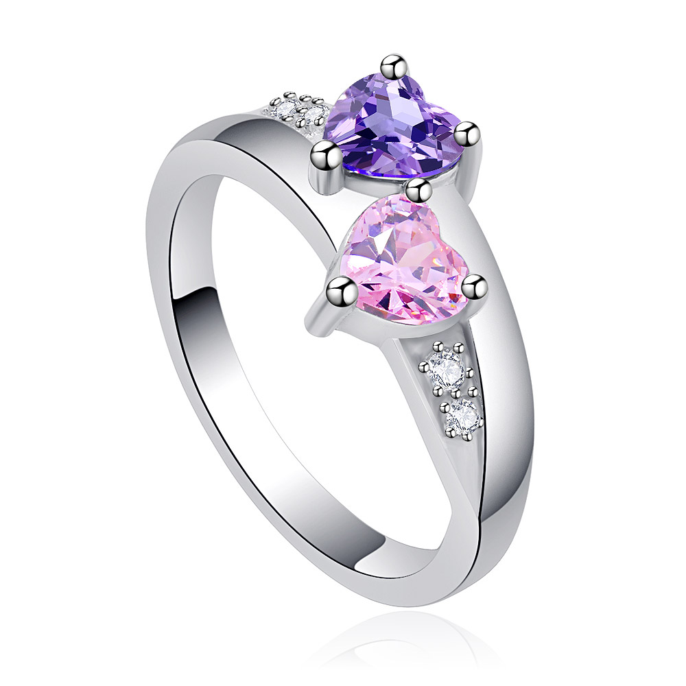 Detailed view of the purple and pink heart gemstones on the ring