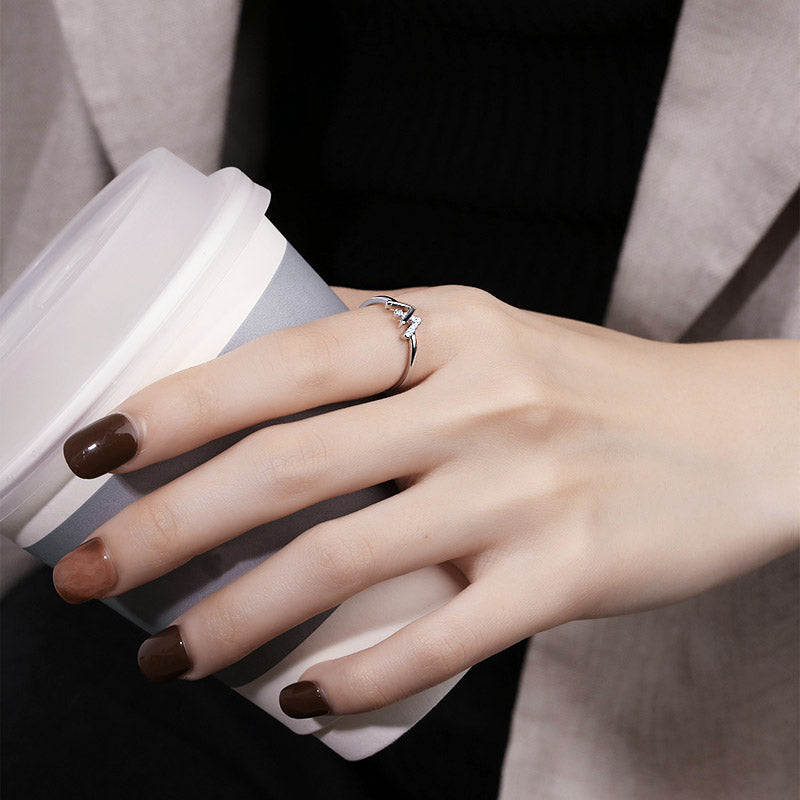 A woman wearing the adjustable W initial ring while holding a cup