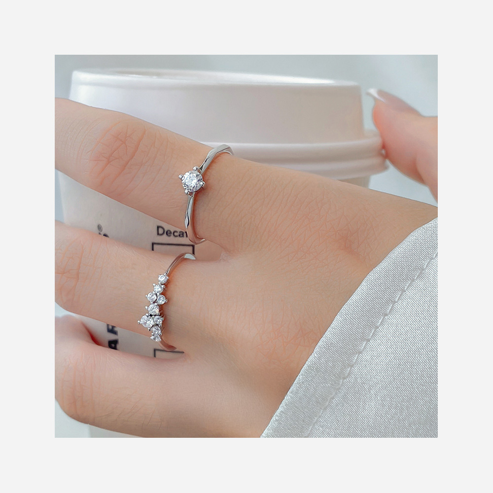 A model's hand wearing stackable sterling silver rings with cubic zirconia