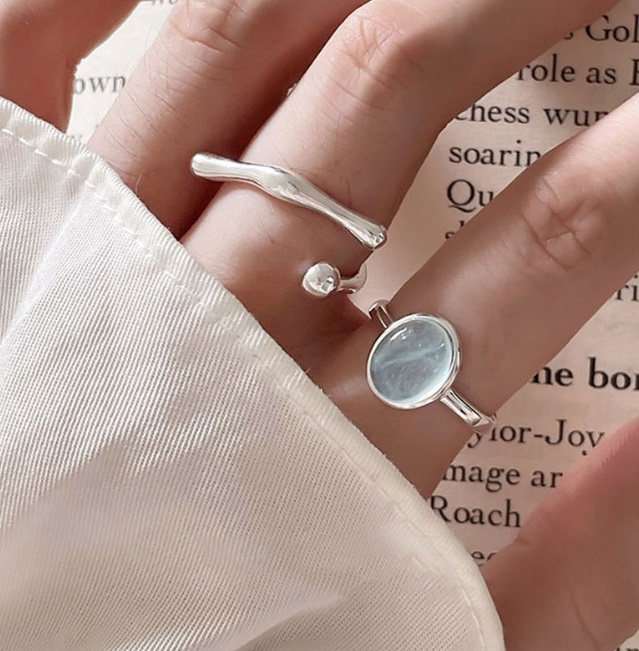Model wearing the 925 sterling silver blue stone ring on hand to show its adjustable fit.