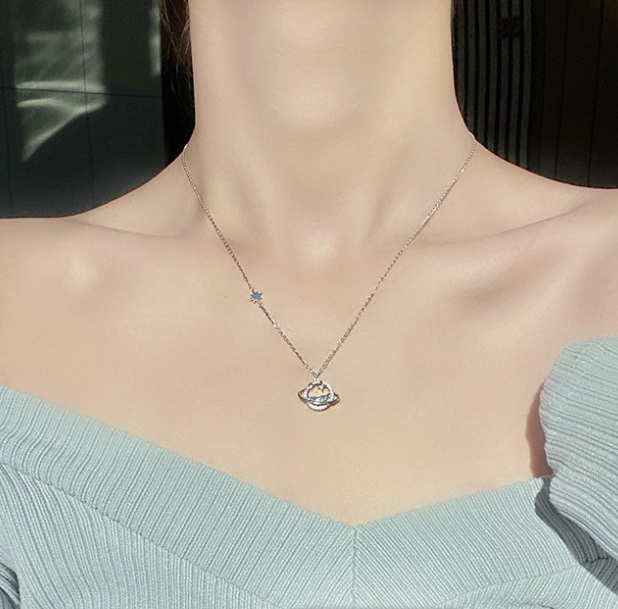 Close-up of the Saturn pendant on the sterling silver necklace