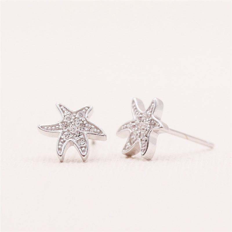 Detailed view of the sterling silver starfish earrings with gemstones
