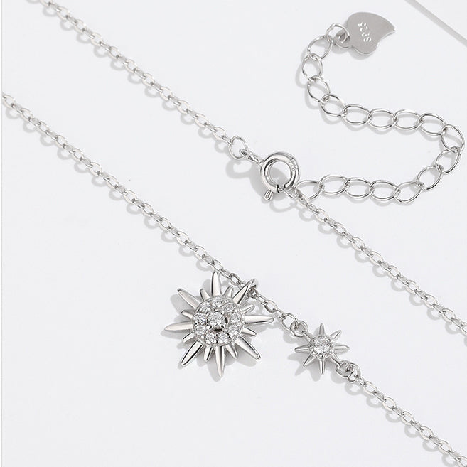 A close-up of the silver sunburst double pendants, showcasing the intricate details and sparkling stones.