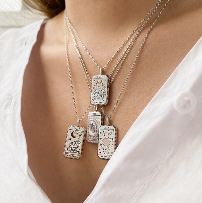 A collection of silver tarot card necklaces showcasing different designs.