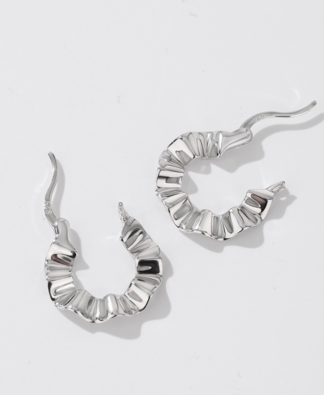A side view of the silver textured wave hoop earrings, showing the crescent shape.