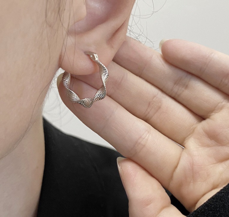 A model showcasing the elegant 925 Sterling Silver Twisted Hoop Earrings