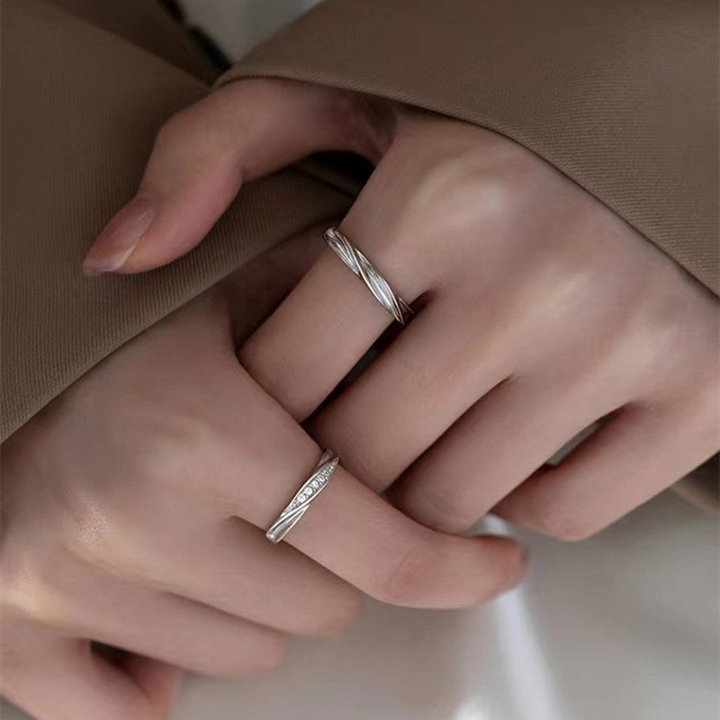 A couple wearing the matching sterling silver wave design rings