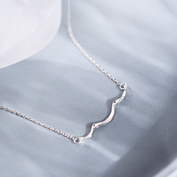 Detailed view of the silver wave pendant