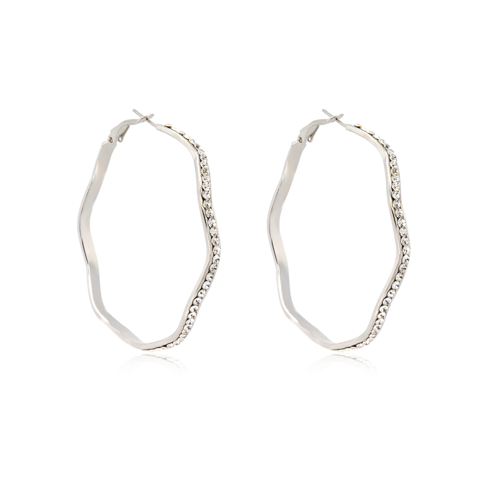 Close-up of the wavy design and crystal details on the rhodium hoop earrings