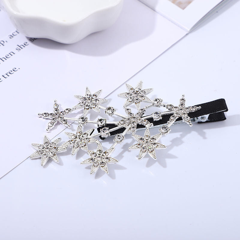 A close-up of the sparkly star-shaped hair clip with clear rhinestones