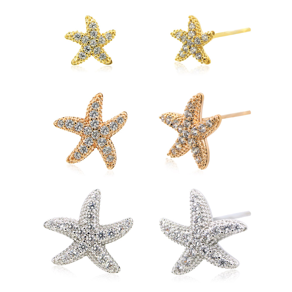 Close-up of gold and silver starfish earrings with clear stones