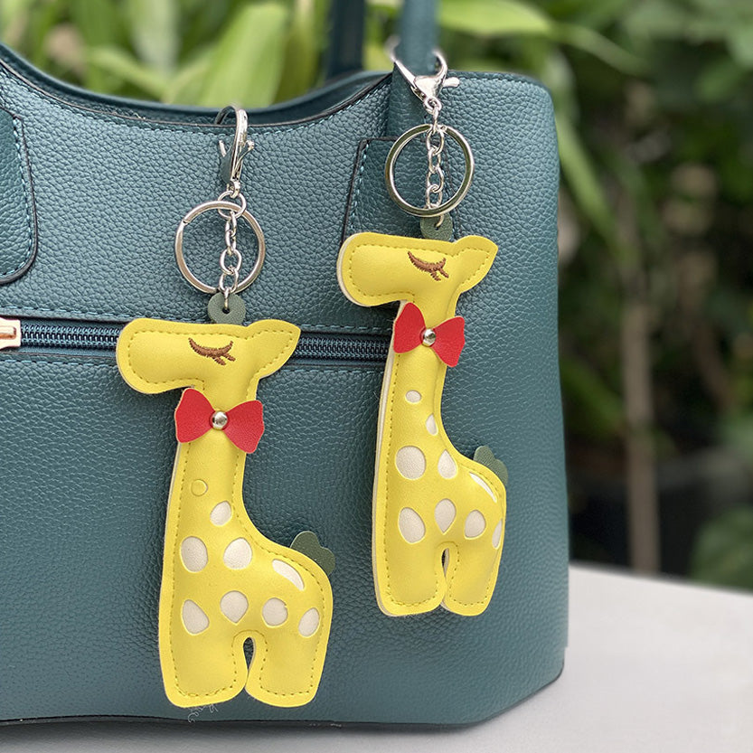 Giraffe keychains adding a playful touch to a teal handbag