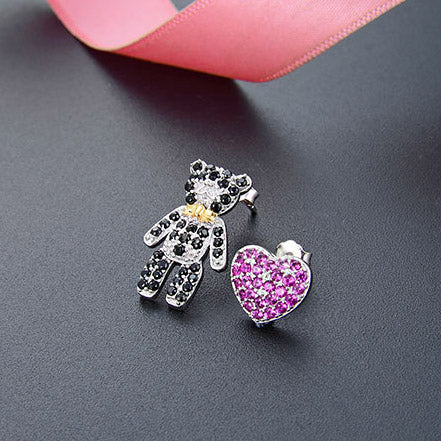 Detailed view of the rhinestone teddy bear and heart stud earrings