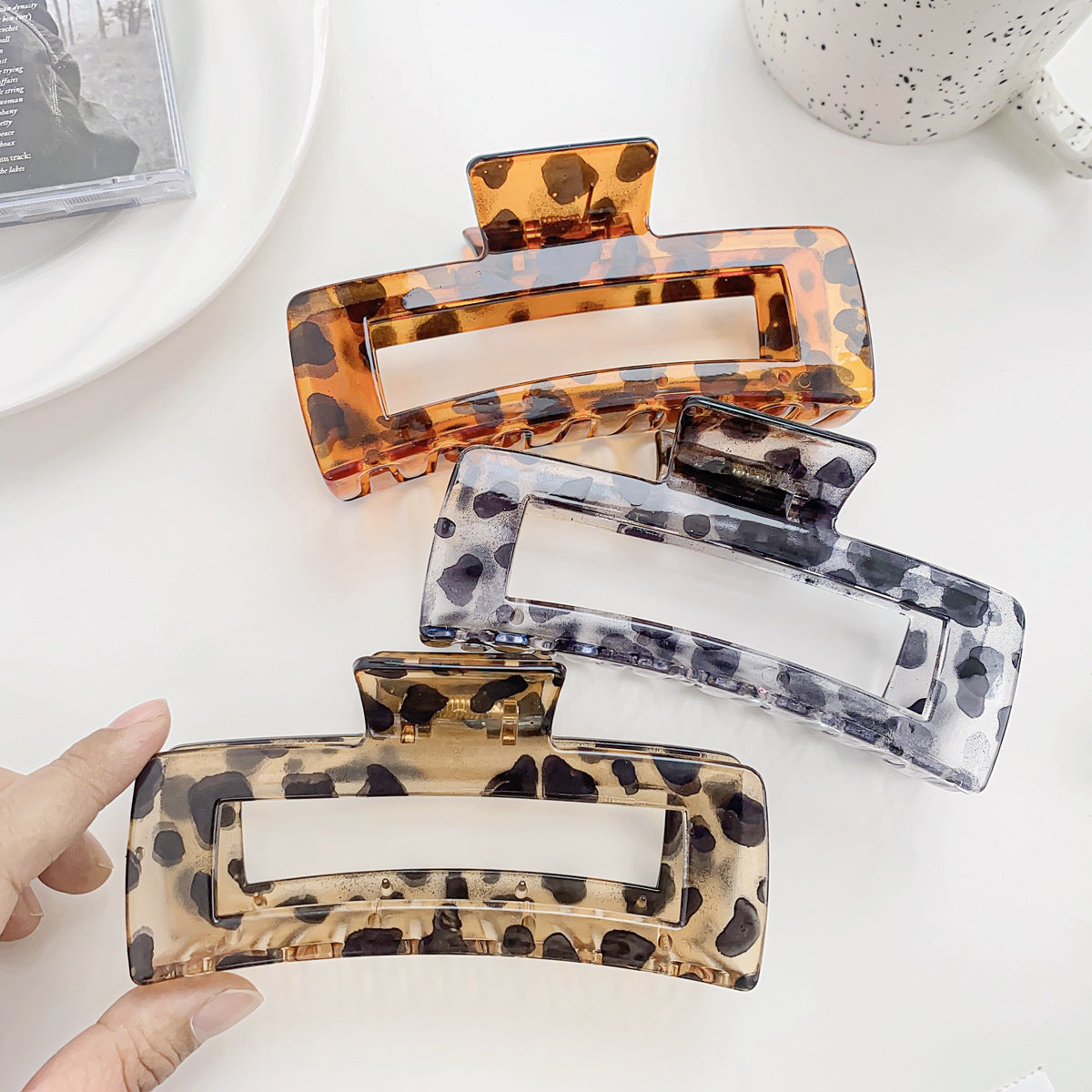 Four large hair claw clips in assorted tortoiseshell patterns