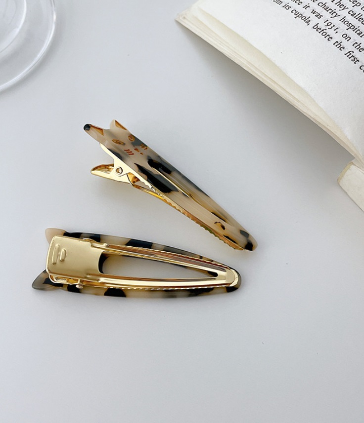 Close-up of tortoiseshell cat hair clips with gold detailing