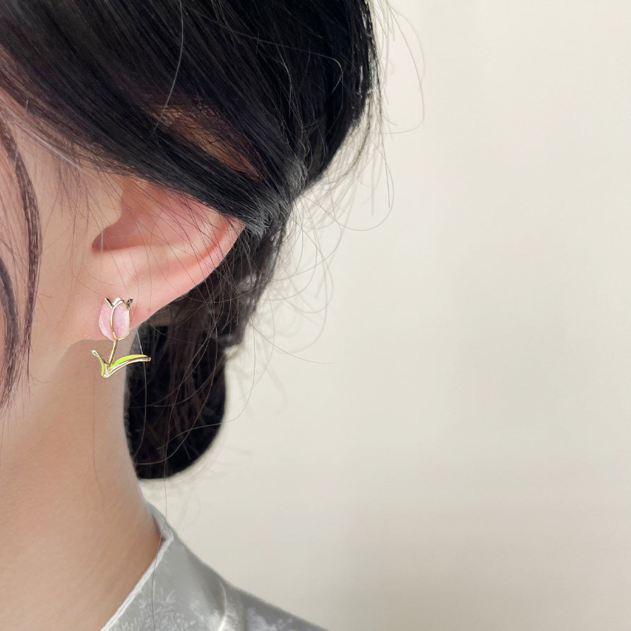 A woman wearing the 14k gold plated enamel tiny tulip flower stud earring.