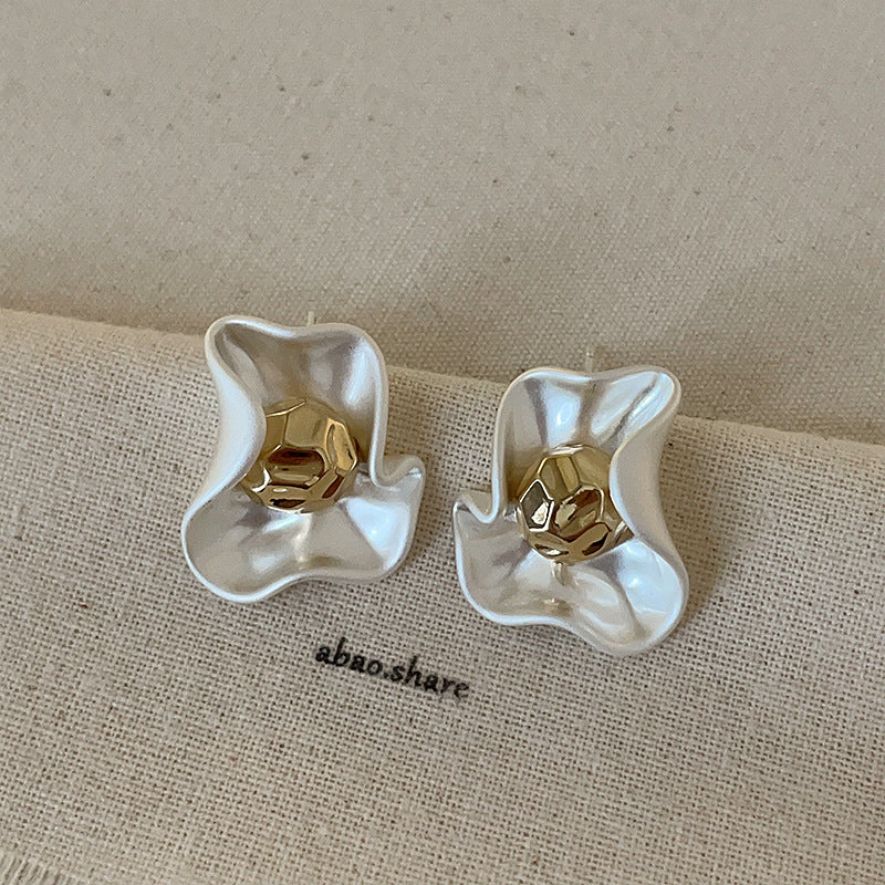 Close-up of the Gold Petal Earrings showing the matte texture and polished center