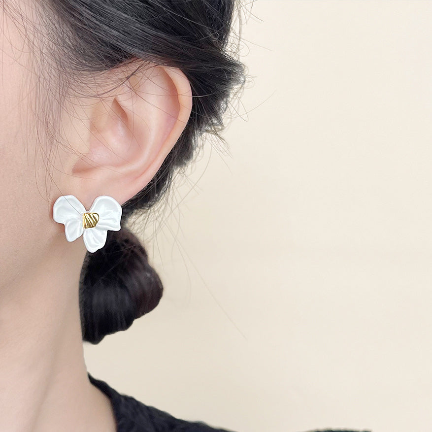 A model showcasing the white enamel knot bow stud earring