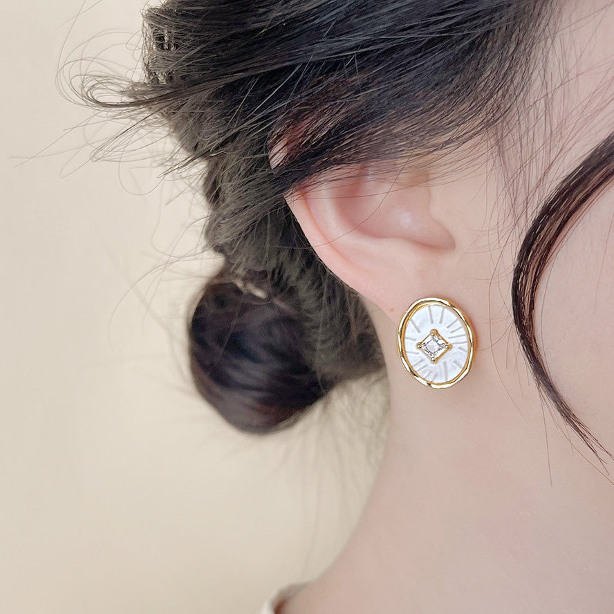 Model showcasing the elegant gold-plated white resin stud earring.