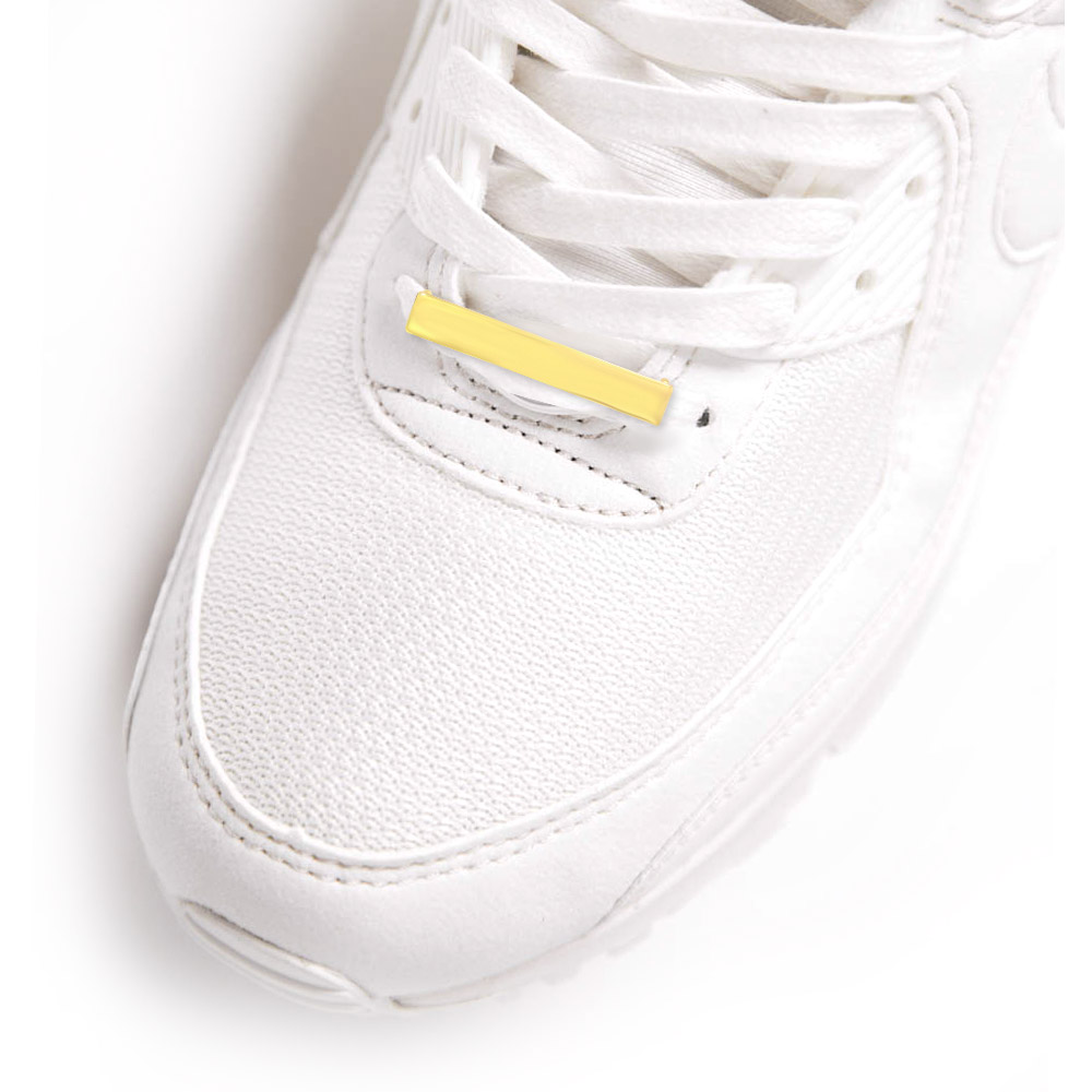 Custom gold shoelace charm showcased on a white sneaker