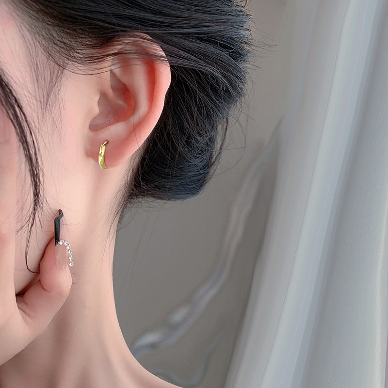 Model showcasing the elegant gold octagon huggie hoop earrings.