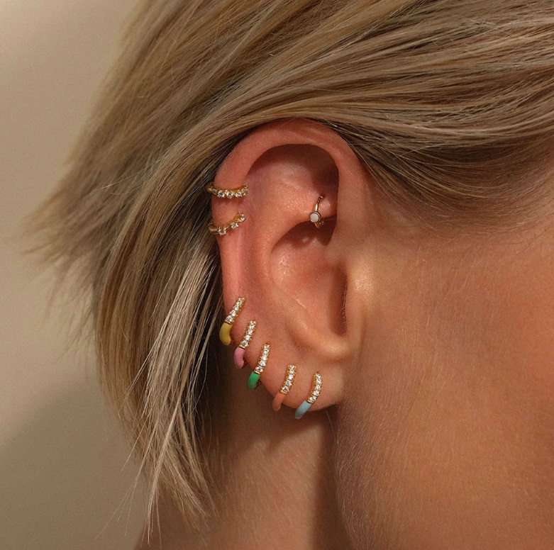 A model wearing multiple 925 Sterling Silver Enamel Stackable Hoop Earrings to create a stylish, layered look.