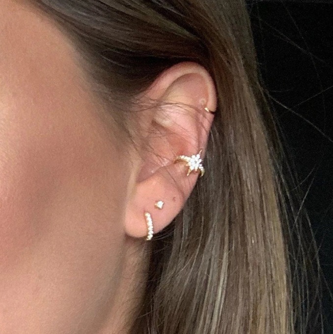 A model wearing the Sunburst Huggie Earrings Set to showcase the style.