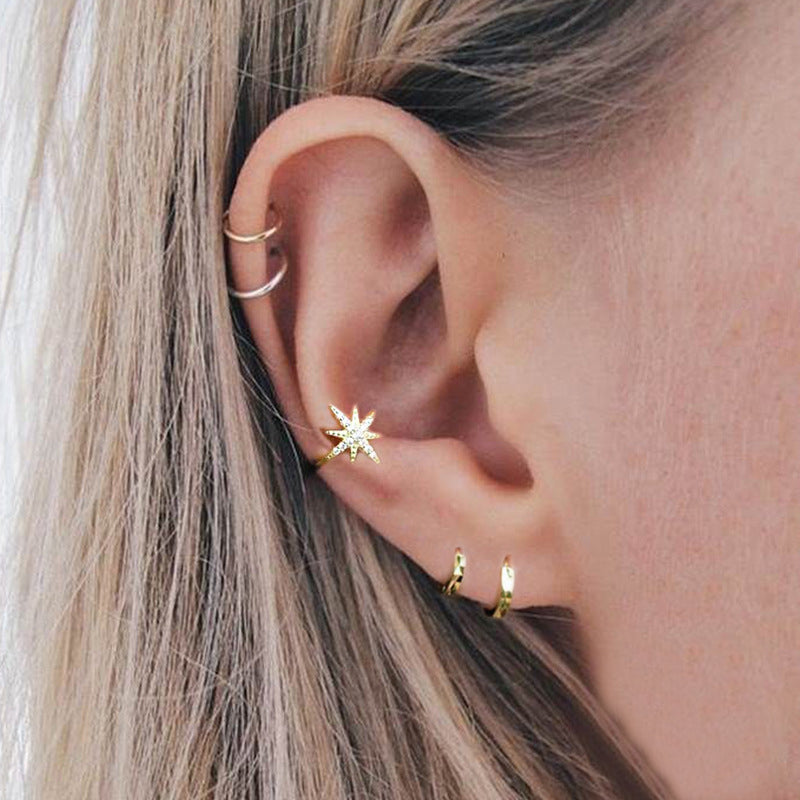 A model wearing the gold starburst zircon ear cuff for a stylish, layered look.