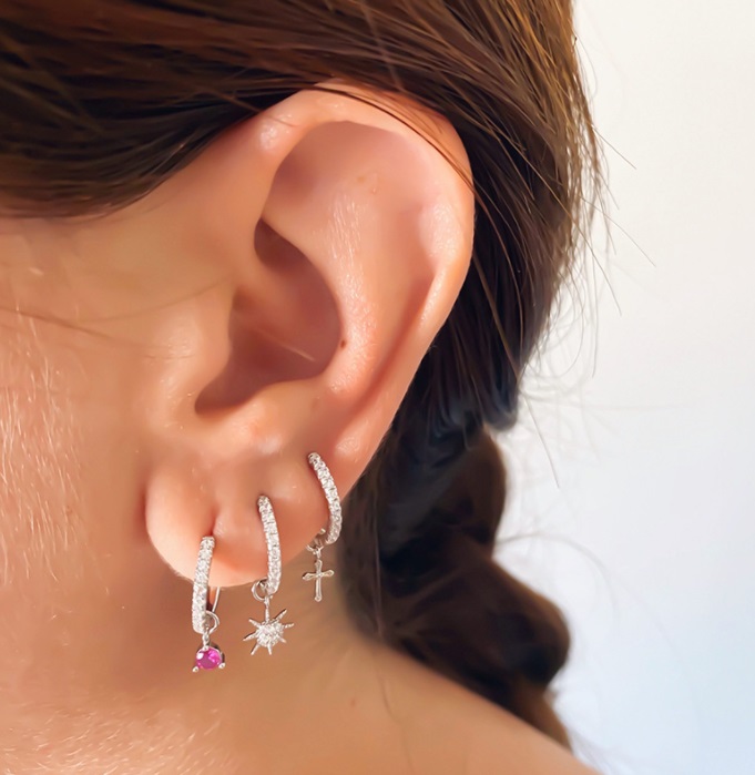 A model's ear adorned with stylish huggie earrings, demonstrating the product's appeal.