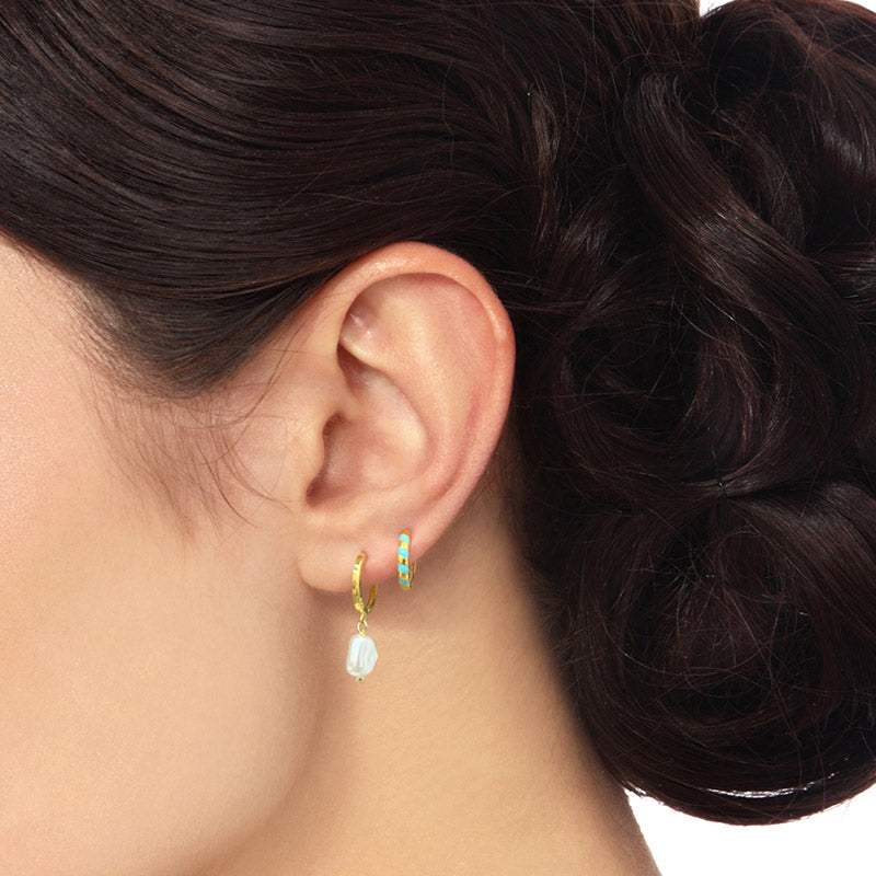 Model showcasing the elegant look of the gold baroque pearl hoop earrings.