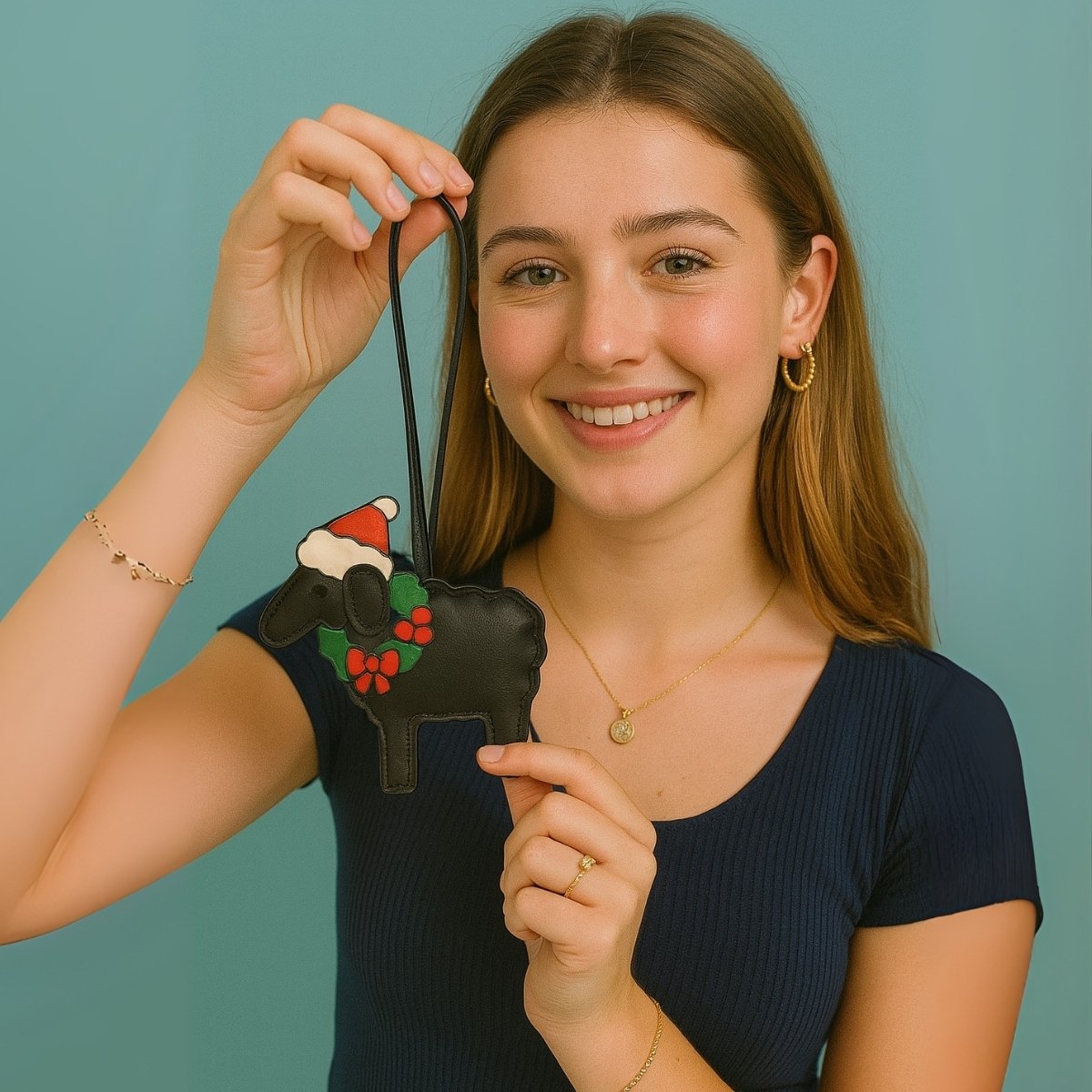 A woman holding a black leather purse with a custom sheep charm