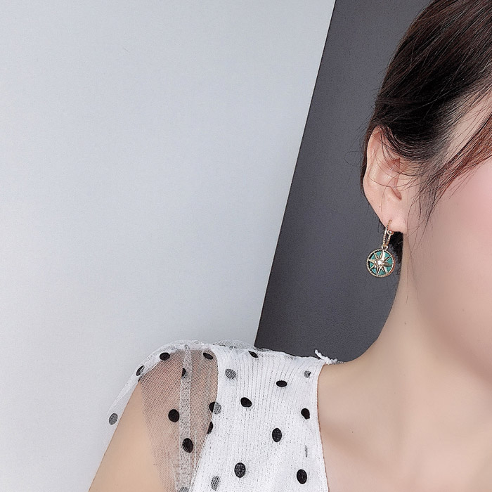 A model showcasing the Palace Green Vintage Art Deco Earrings with a stylish outfit.