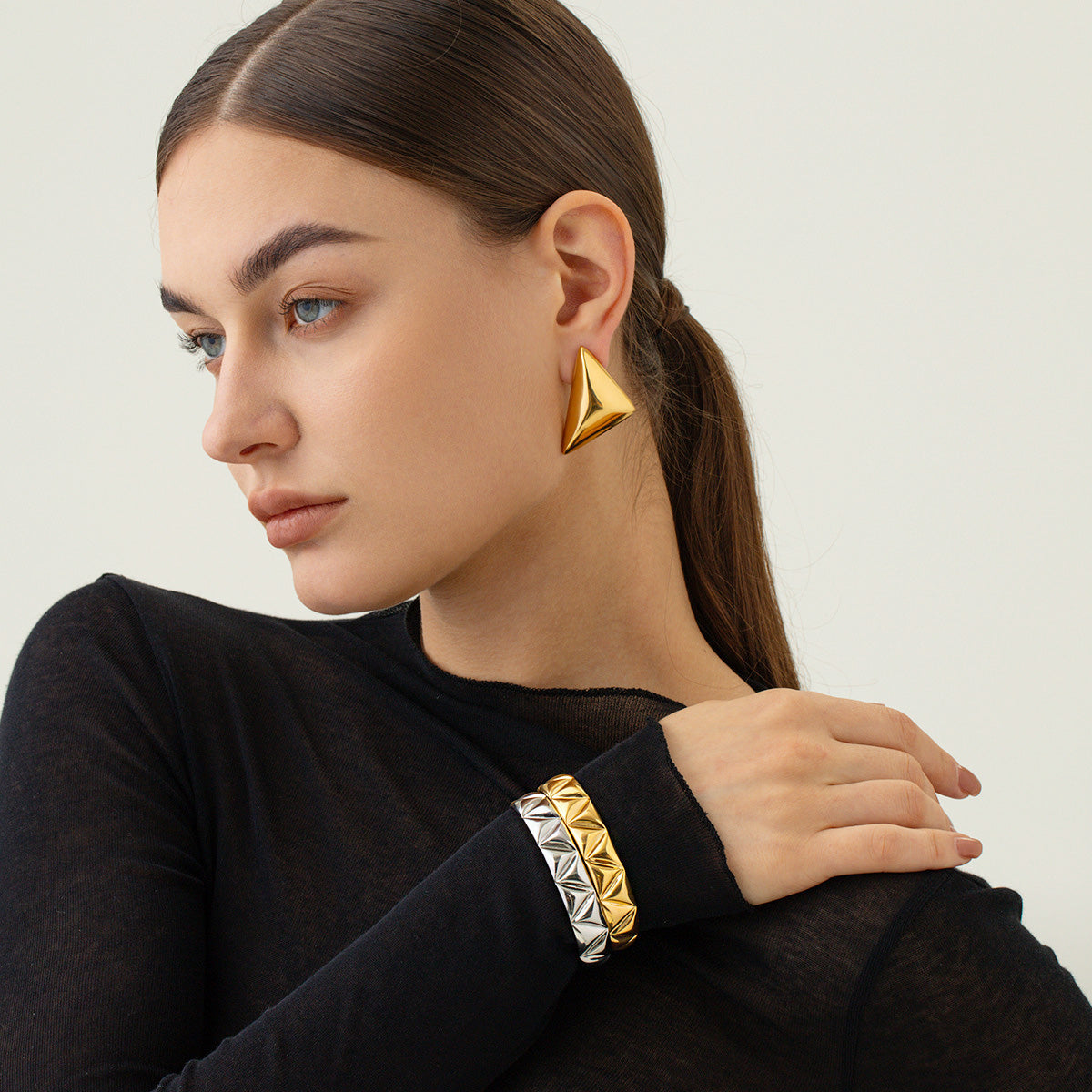 A model showcasing the versatile styling of the geometric cuff bracelets.