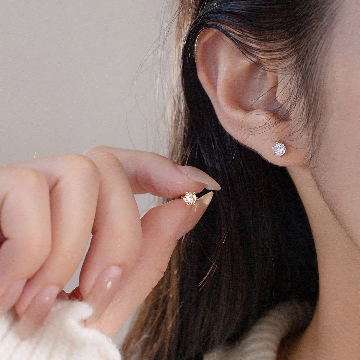A woman wearing the 925 silver cubic zirconia stud earring, showcasing its elegant look.